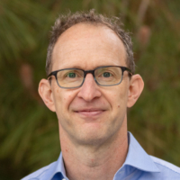 portrait image of man with glasses and blue shirt