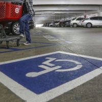 Image of undercover police officer standing next to disabled parking spot to monitor for "improper" use of disabled parking permits