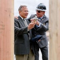 image of Mayor of Danville and handing the Town Manager a hammer at the ceremony of the construction site of new housing development
