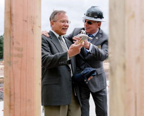 image of Mayor of Danville and handing the Town Manager a hammer at the ceremony of the construction site of new housing development