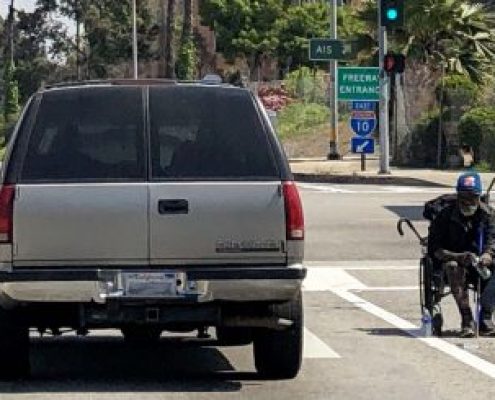 Image of homeless man on seated in the middle of a street