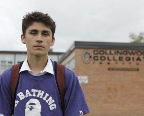 image of young, Canadian student in front of his school