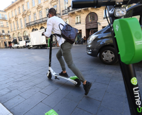 image of person riding a Lime scooter