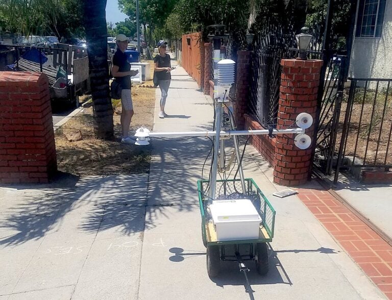 |City workers apply a cooling paint on roads in Pacoima