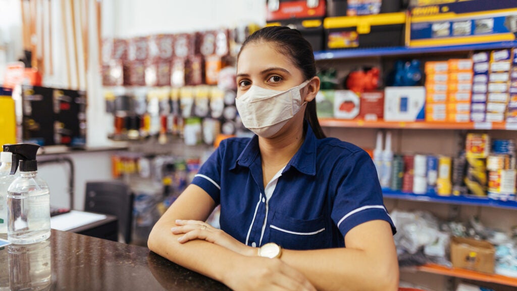 Young woman wearing face mask working in hardware store