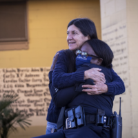 image shows professor Jorja Leap hugging a police officer