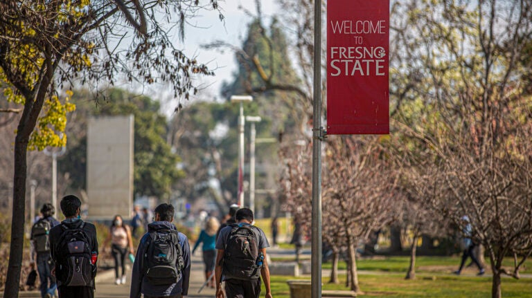 Students with backpacks walking outside at Fresno State campus