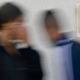Blurred photo of two students walking by anti-bullying poster in a classroom.