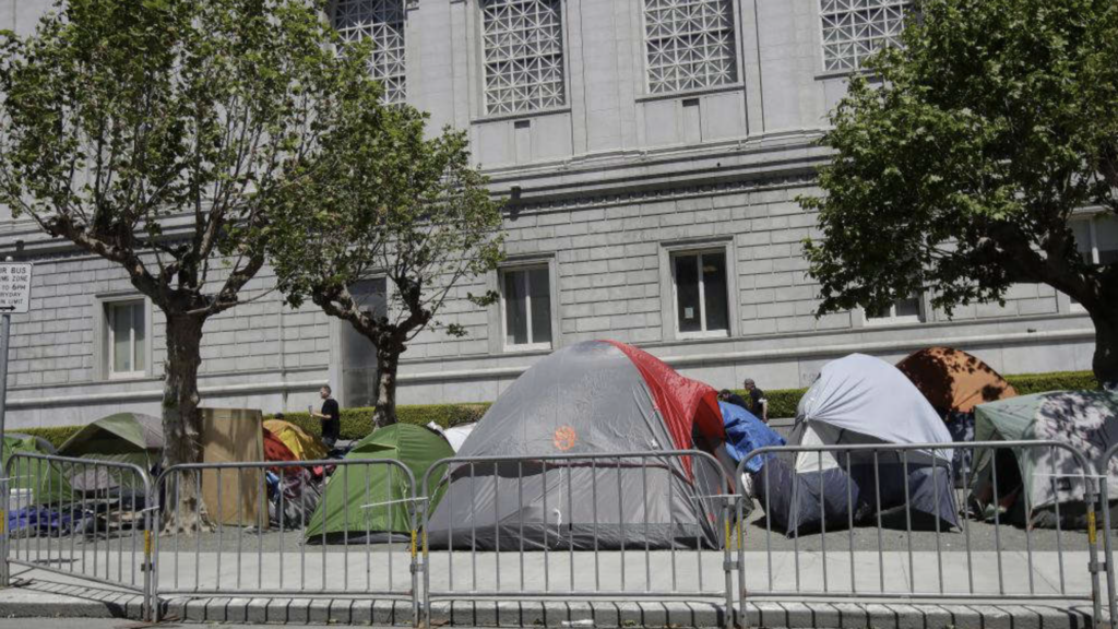 Tents at a homeless encampment in front of a building