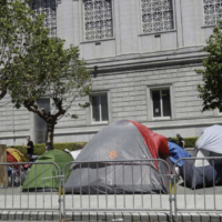 Tents at a homeless encampment in front of a building