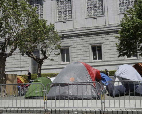Tents at a homeless encampment in front of a building
