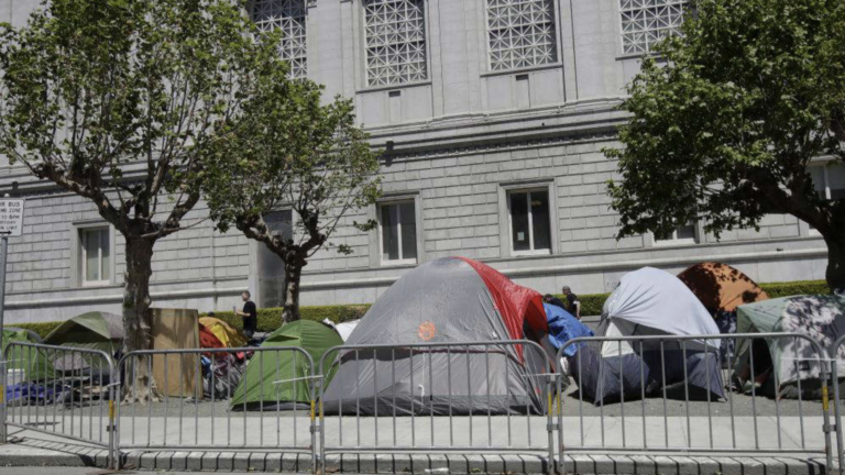 Tents at a homeless encampment in front of a building