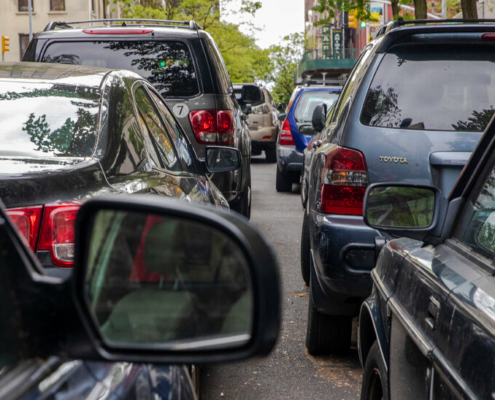 A line of double-parked cars on a New York City street.