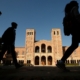 Silhouettes of students walk by in front of Royce Hall on UCLA campus.