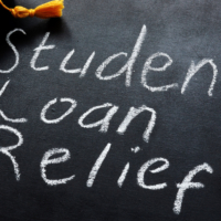Student loan relief written on the blackboard and graduation cap.