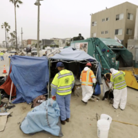 Los Angeles sanitation workers clear a homeless encampment on the beach in Venice, California.