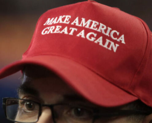 Close-up image of a man wearing a red "Make America Great Again" hat.