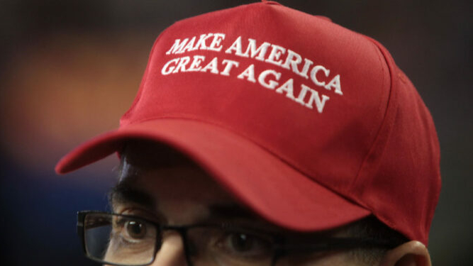 Close-up image of a man wearing a red "Make America Great Again" hat.