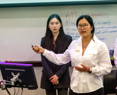 five young women in front of an erasable board in a classroom