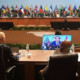 delegats at conference tables with international flags