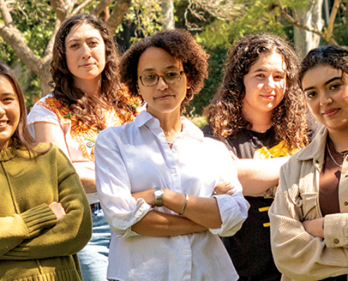 young people with arms folded pose outside