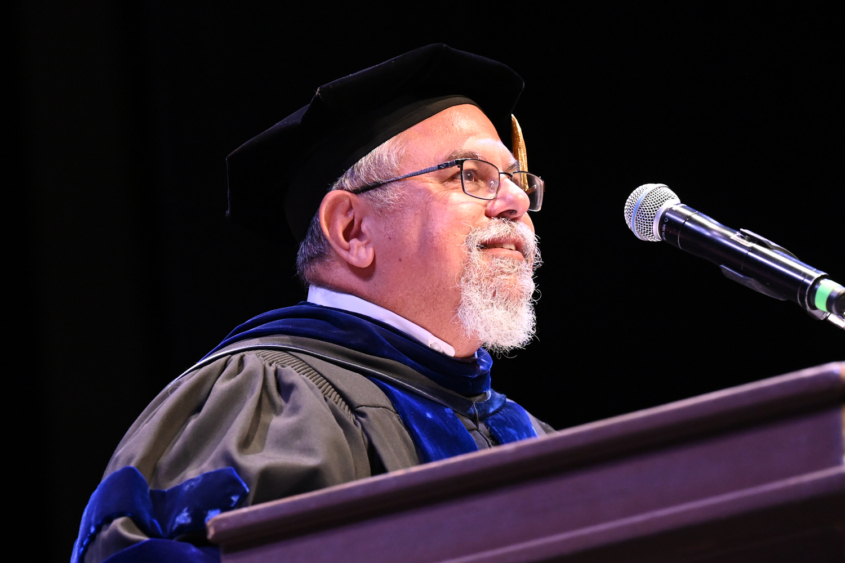graduation speaker with beard at podium