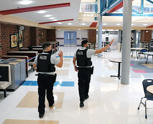 two school police officers in campus cafeteria