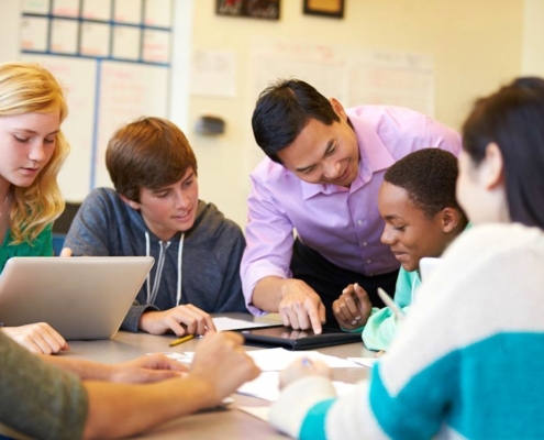 teacher with students sitting at table
