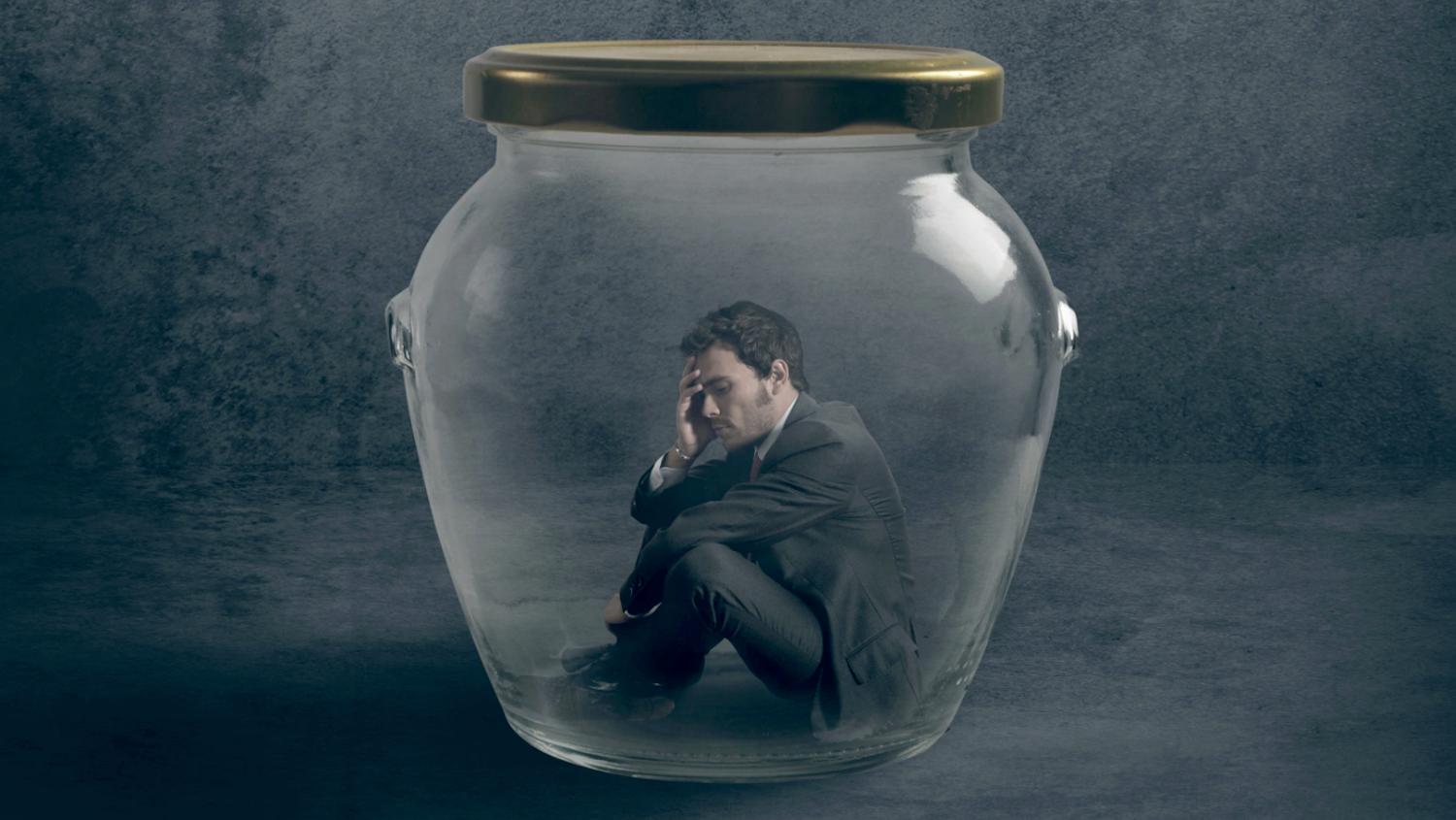 Man Sits On Glass Jar