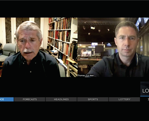 two men on screen during television interview