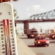 Thermometer reads 100 degrees Fahrenheit with cars driving on a street in the background