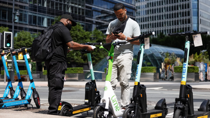two men near electric scooters for rent