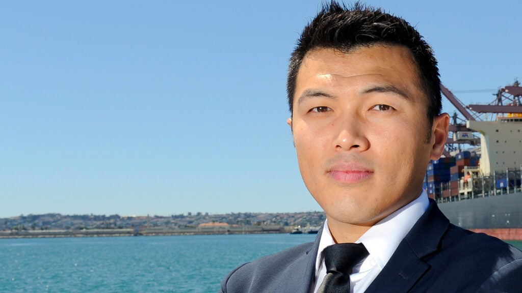 closeup photo of man standing outside near a body of water