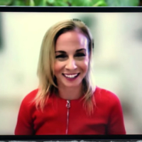 woman in red smiles during interview being conducted remotely