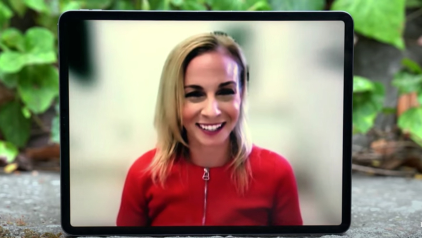 woman in red smiles during interview being conducted remotely