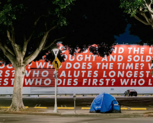 blue tent in front of red and white mural
