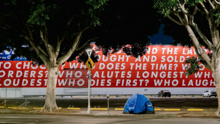 blue tent in front of red and white mural