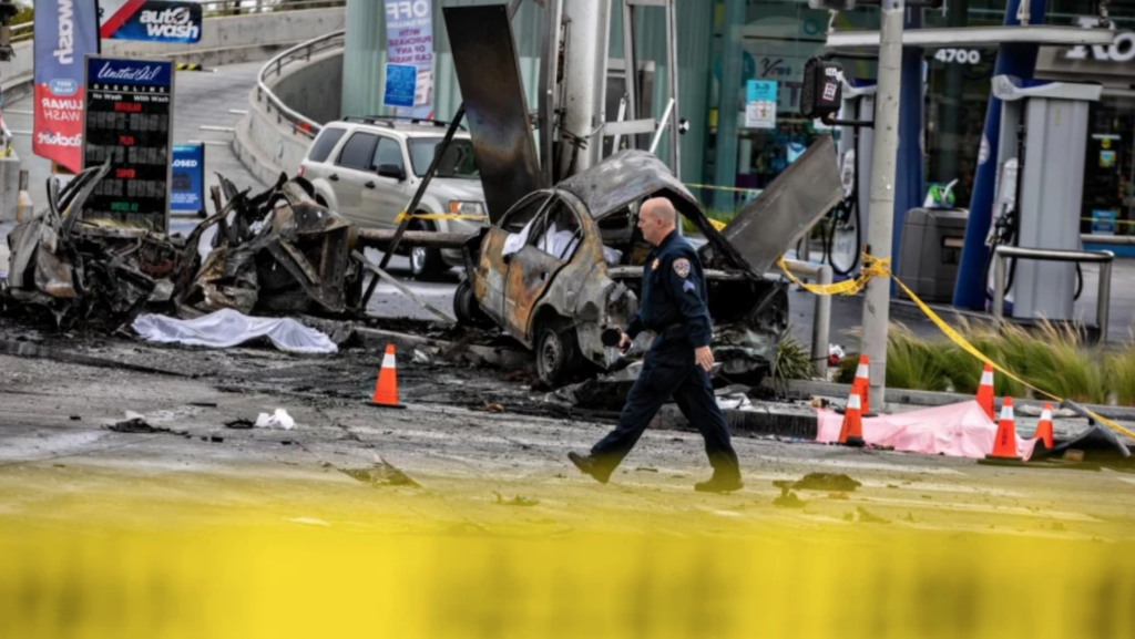 police officer in front of wrecked cars
