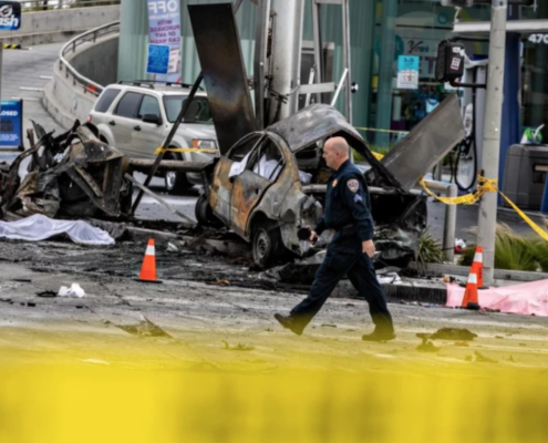 police officer in front of wrecked cars