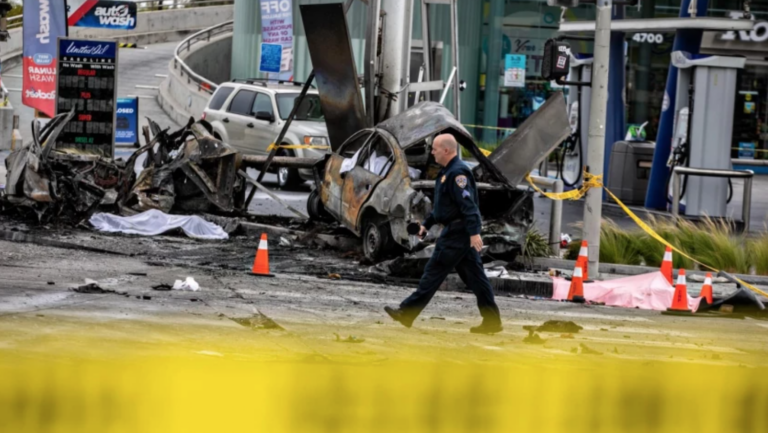 police officer in front of wrecked cars