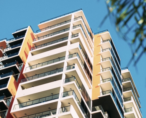 Apartment buildings with balconies set against blue sky