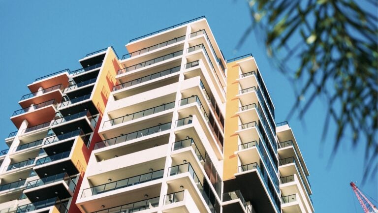 Apartment buildings with balconies set against blue sky