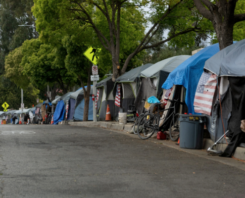 sidewalk lined with tents housing homeless people