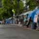 sidewalk lined with tents housing homeless people