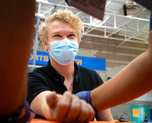 Masked young man receiving vaccine