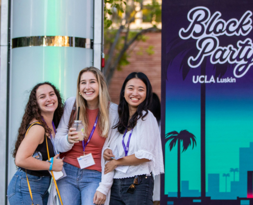 three women in front of "Block Party" sign