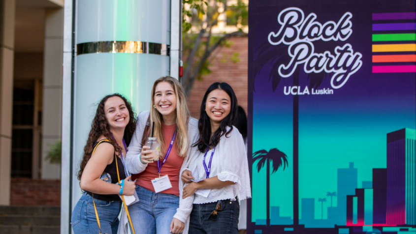 three women in front of "Block Party" sign