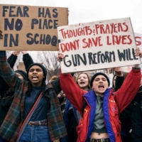 students holding signs promoting gun reform