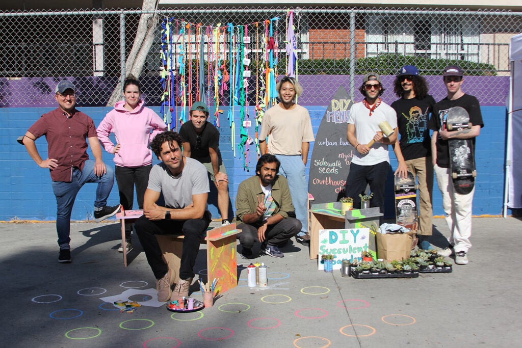 about 10 people who served as organizers and participants pose with amenities from the event|image shows event organizers facing camera|||