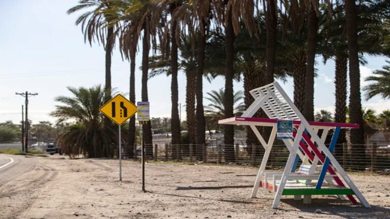 A shade structure is built around a bus stop